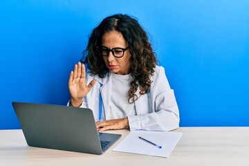 Poster - Beautiful middle age doctor woman doing video call waving to laptop skeptic and nervous, frowning upset because of problem. negative person.