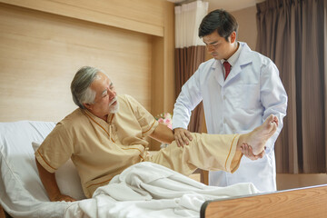 doctor examining the knee and leg  after surgery of asian senior old man patient suffering from pain in knee on bed in medical office room at hospital . diversity  people