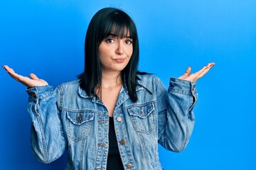 Sticker - Young hispanic woman wearing casual denim jacket clueless and confused with open arms, no idea and doubtful face.