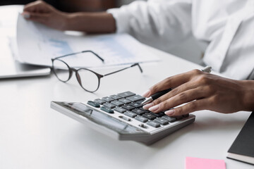 Wall Mural -  Accountant calculate finance report using calculator and holding document closeup, business woman working in finance accounting and analyse financial budget in office 