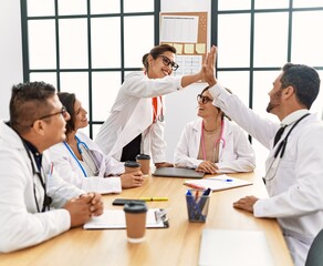 Wall Mural - Group of doctor smiling happy and looking parters high five at clinic office.