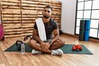 © Krakenimages.com - Young indian man sitting on training mat at the gym depressed and worry for distress, crying angry and afraid. sad expression.