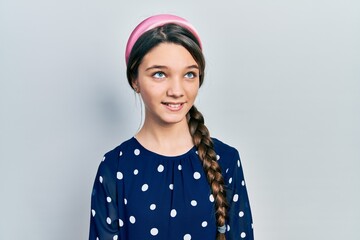 Wall Mural - Young brunette girl wearing elegant look looking away to side with smile on face, natural expression. laughing confident.