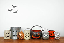 Halloween Shelf Display With Row Of Rustic Jack O Lantern Candle Holders Against A White Wall With Bats. Wood Shelf. Banner With Copy Space.