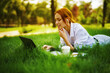 Image of beautiful young pretty redhead woman in park outdoors using laptop computer for study or work