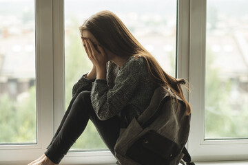 bullying teenager school,teen girl is crying on the window,harassment and teasing, abuse of peers