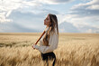© ADDICTIVE STOCK - Stylish model in wheat field under cloudy sky