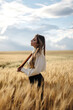 © ADDICTIVE STOCK - Stylish model in wheat field under cloudy sky
