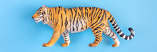 The Tiger, Symbol Of 2022 Year. Plastic Orange Toy Figure Tiger On A Blue Background. Top View. Banner