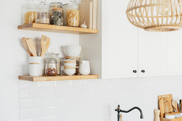 Wall Mural - Kitchen shelves with various white ceramic, glass jars, cookbook. Open shelves in the kitchen. Kitchen interior open shelving ideas. Eco friendly kitchen, zero waste home concept