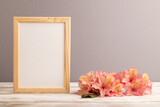 Fototapeta  - Wooden frame with pink azalea flowers on gray pastel background. side view, copy space.