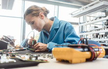 Worker In Electronics Manufacturing Soldering A Component For The Prototype Series By Hand