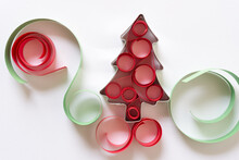 Christmas Cookie Cutter In The Shape Of A Tree Decorated With Paper Swirls On White