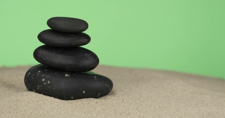 Wall Mural - Pyramid made of black stones on the sand. Rotation. Isolated