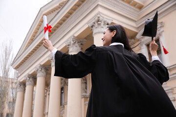 Poster - Student with diploma after graduation ceremony outdoors, low angle view