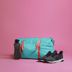 Wall Mural - Blue gym bag and sports accessories on pink background