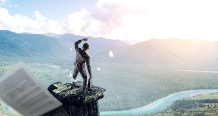 Wall Mural - young businessman standing and rock mountain . mixed media