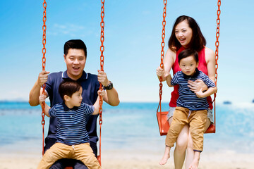 Wall Mural - Happy parents playing swings with sons on beach