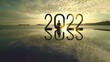 © Creativa Images - Woman exercising yoga with 2022 numbers at sunset