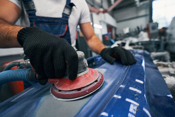 Poster - Repair shop worker sanding car with grinding machine