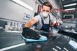 © Viacheslav Yakobchuk - Hard-working male cleaning car in auto repair shop