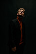 © SHOTPRIME STUDIO - fashionable man in jacket and sweater looking up against a dark background