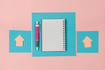 Sheets of a paper, open notebook, arrow bookmarks, pen on pink background. Blue square sheets of paper. Clean notepad on a spring. Top view.