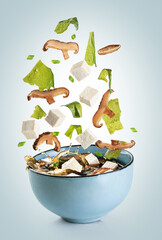 Wall Mural - Miso soup ingredients fall into the bowl. Shiitake mushrooms, tofu cheese, fresh onions and wakame seaweed.