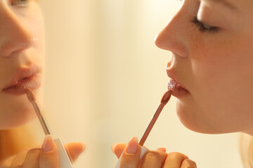 Wall Mural - Woman painting lips looking at mirror