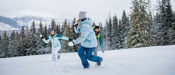 family with small daughter having fun outdoors in winter nature, tatra mountains slovakia.