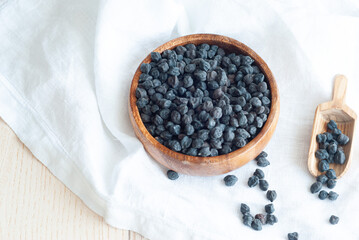 Black chickpeas in a wooden plate on a wooden backround