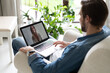 © opolja - Male remote working from home and having work confrence video call.