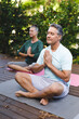© WavebreakMediaMicro - Happy senior caucasian couple practicing yoga, meditating in sunny garden