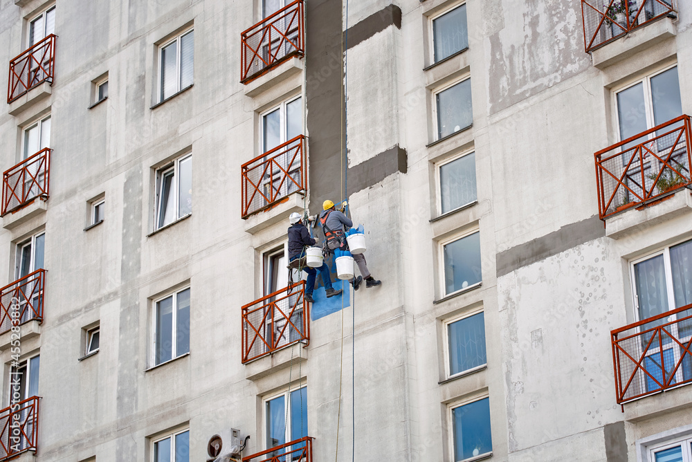 Rope access job, construction workers repair and restore facade of high ...