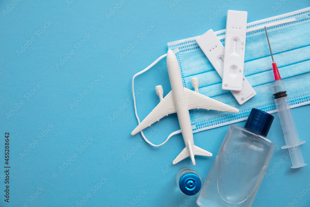 Covid air travel background. Airplane with a coronavirus protective face mask vaccine needle and test - obrazy, fototapety, plakaty 