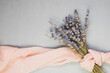 A bouquet of dried lavender and a chiffon scarf on a gray background. Flat lay, place for text.
