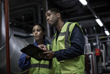 Male Engineer And Female Engineer Working Together In An Industrial Plant Room