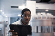 © ReeldealHD images - African American male scientist recording data on a digital tablet in a laboratory