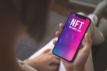 Woman using mobile phone for NFT trading. Concept of non-fungible token, crypto art and blockchain