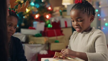 happy african american girl unwrapping christmas presents excited for special gift children having f