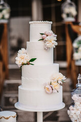 Poster - Vertical shot of a beautifully decorated white wedding cake outdoors