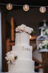 Poster - Vertical shot of a beautifully decorated white wedding cake outdoors