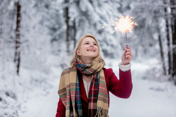 Sticker - blonde in a red coat with sparkler in a snowy forest