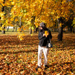 © Vladimir - A girl in a hat in a yellow autumn maple forest holds yellow maple leaves in her hands. Autumn mood.