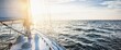 © Aastels - Yacht sailing in an open sea at sunset. Close-up view of the deck, mast and sails. Clear sky after the rain, glowing clouds, golden sunlight. Panoramic seascape