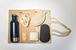 Artículos zero waste sobre una bolsa tote bag. Botella de agua de acero inoxidable, spork, esponja de lufa, compresa menstrual reutilizable, champú sólido, cepillo de dientes de bambú
