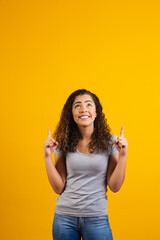 Afro woman pointing in yellow background with space for the text