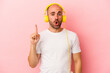 © Asier - Young caucasian bald man listening to music isolated on pink background  having some great idea, concept of creativity.