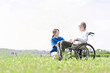 芝生で会話をする高齢者と介護士