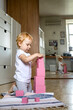 Cheerful toddler arrangement pink cubes assembling tower educational Maria Montessori materials